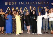 winners of the 2025 Best in Business Awards lined up on stage with their awards